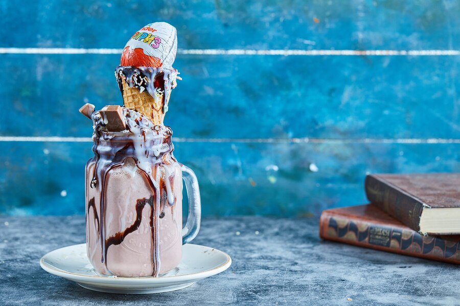 chocolate milkshake with bar chocolate kinder surprise ice cream cone white plate_114579 33859