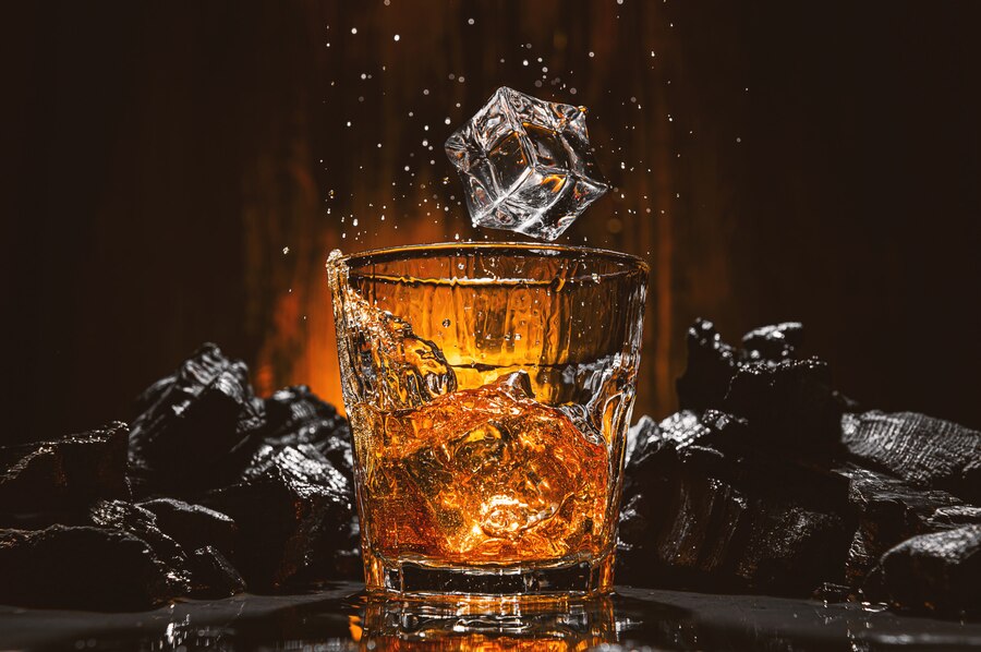 ice cubes fall into glass with brown alcoholic drink_152625 2705